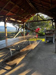 a wooden bench sitting under a roof with a view at Las cabañas del Francés in Alto Boquete