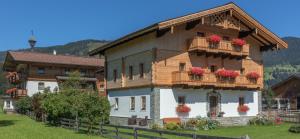 dom z kwiatami na balkonach w obiekcie Landhaus Fingerhof w mieście Flachau