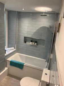 a bathroom with a tub and a toilet and a sink at Large Three bed Two bathroom flat in Central Torquay in Torquay