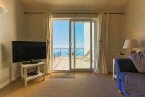 ein Wohnzimmer mit einem TV und Meerblick in der Unterkunft PUTSBOROUGH CLIFTON COURT 17 1 Bedroom in Croyde