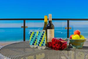 ein Tisch mit zwei Flaschen Wein und einer Schale Obst in der Unterkunft PUTSBOROUGH CLIFTON COURT 17 1 Bedroom in Croyde