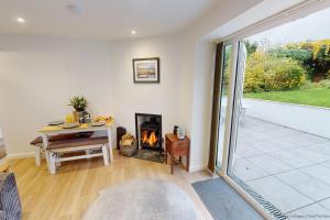 ein Wohnzimmer mit Tisch und Kamin in der Unterkunft BRAUNTON ORCHARD COTTAGE 2 Bedrooms in Braunton