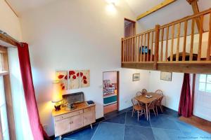 ein Wohnzimmer mit einem Tisch und einer Holztreppe in der Unterkunft BUCKLAND BREWER COB BARN 2 Bedrooms in Buckland Brewer + 15 Fotos