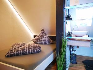 een kamer met kussens op een bank met een wastafel bij Apartment-96 in Weingarten