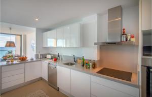 eine Küche mit weißen Schränken und einer Spüle in der Unterkunft 3 Bedroom Cozy Apartment In Villajoyosa in Villajoyosa