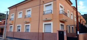 un gran edificio naranja con ventanas y una puerta en Apartamento14 Ruidera AguaPlacer, en Ruidera