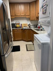 a kitchen with wooden cabinets and a refrigerator at Pearlridge Gardens and Tower Aiea, Hawaii 96701 in Aiea