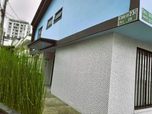 een wit gebouw met een poort en wat gras bij Casa Azul in Manizales