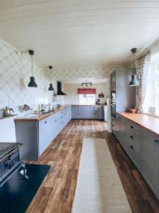 uma grande cozinha com pisos em madeira e electrodomésticos em aço inoxidável em Øygarden i Heggjabygda em Nordfjordeid