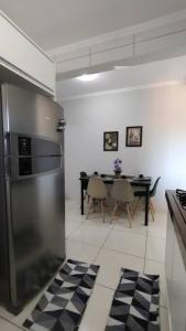 uma cozinha com um frigorífico de aço inoxidável e uma mesa em Apartamento Doce Aconchego - RESIDENCIAL WAKI 05 em Dourados