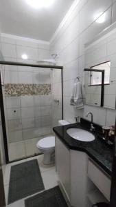 uma casa de banho branca com um lavatório e um WC em Apartamento Doce Aconchego - RESIDENCIAL WAKI 05 em Dourados