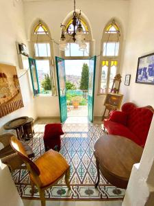 sala de estar con sofá rojo y sillas en Al Mutran Guest House, en Nazaret
