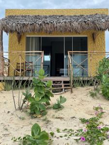 a small hut with a bench and chairs on the beach at Bangalô Encantador Praia da Baleia in Itapipoca