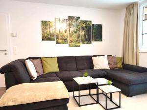 a living room with a couch and paintings on the wall at Modern Mountain Apartment - free parking & sauna in Obertauern