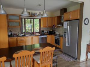 eine Küche mit Holzschränken, einem Tisch und einem Kühlschrank in der Unterkunft Roses Villa in Trimiklini