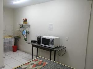 a microwave sitting on a table in a kitchen at Aquarela Suítes in Piúma