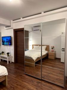 a bedroom with a bed with a glass wall at Cozy Apartment with Self Check-in near Promenada Mall and Verdi Park in Bucharest