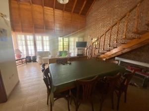 sala de estar con mesa verde y escaleras en Family House en Monte Hermoso