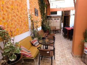 a room with a couch and tables and chairs at Eco Bunnu Inn in Cusco