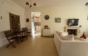 ein Wohnzimmer mit einem weißen Sofa und einem Fernseher in der Unterkunft Villa Destiny in Pefkohori