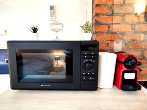 a microwave oven sitting on top of a table at Leopold Room 30m2 Hyper centre, Netflix & Wi-fi in Épinal