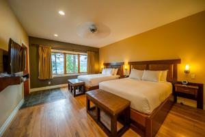 a bedroom with two beds and a flat screen tv at Halcyon Hot Springs Resort in Halcyon Hot Springs
