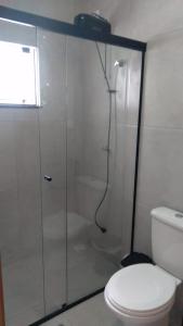 y baño con ducha de cristal y aseo. en LOFT do Sonho!, en Palhoça
