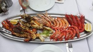 a plate of shrimp and other seafood on a table at 204 I Posada del Mar I Encantador hostel en la playa de Gandia in Los Mártires