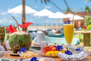 uma mesa com comida e uma bebida em cima em Villa Pantai Boutique Hotel Maragogi em Maragogi