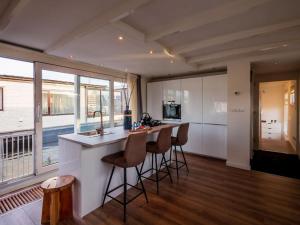 a kitchen with a counter and bar stools in a room at Quiet Waterloft near Amsterdam and Schiphol WS17 in Aalsmeer