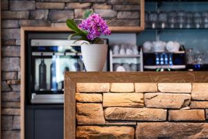 um vaso de flores sentado em cima de uma parede de tijolos em Hotel Zur Traube em Brigerbad