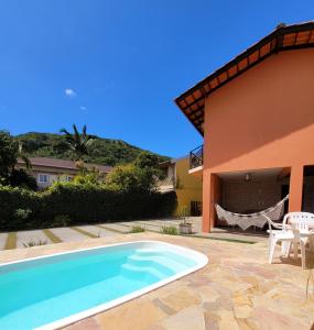 a swimming pool in front of a house at Partiu Praia SC in Guarda do Embaú