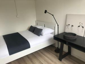 um quarto com uma cama com uma secretária e pássaros na parede em Quiet Waterloft near Amsterdam and Schiphol WS17 em Aalsmeer