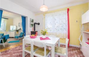 a dining room with a white table and chairs at Beautiful Home In Palit With Kitchen in Rab