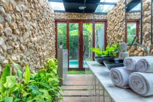 um quarto com uma parede de pedra e algumas plantas em Villa Pantai Boutique Hotel Maragogi em Maragogi