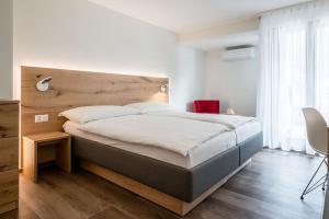 a bedroom with a large bed with a wooden headboard at Hotel Zur Traube in Brigerbad