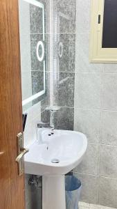 a bathroom with a white sink and a shower at فيو إن للشقق الفندقية - المحالة in Abha