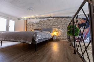 a bedroom with a bed and a stone wall at Soho Boho Apartments - with sunny rooftop terrace and fiber optic internet in Alicante