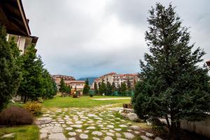 a garden with a tree and a stone path at Studio Stankovic Royal Towers 326 in Bansko