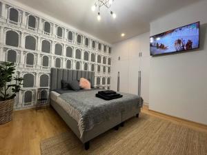 sypialnia z łóżkiem i telewizorem na ścianie w obiekcie Słoneczny Apartament Koszykowy! w Warszawie
