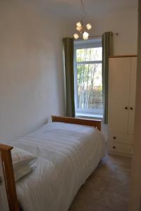 1 dormitorio con cama y ventana en Entire 3 bedroom house near Caerphilly station, en Caerphilly