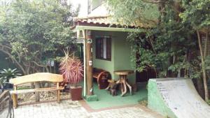 una pequeña casa con un perro sentado frente a ella en Karaguashouse, en Florianópolis