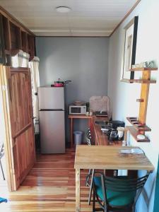 a small kitchen with a table and a refrigerator at Bungalow Batsù in Fortuna