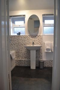 a bathroom with a sink and a mirror at Entire 3 bedroom house near Caerphilly station in Caerphilly