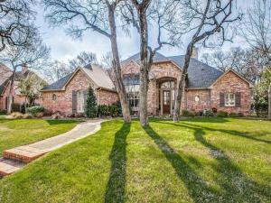 a brick house with a tree in the yard at Executive home w/Study + pool near Lake in Rockwall