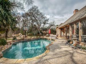 a swimming pool in front of a house with a basketball hoop at Executive home w/Study + pool near Lake in Rockwall