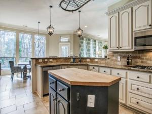 a large kitchen with white cabinets and a counter top at Executive home w/Study + pool near Lake in Rockwall