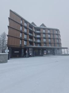 a large building with a parking lot in front of it at Kopaonik Woodside in Kopaonik