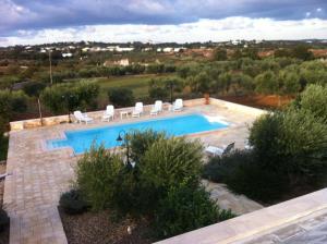 a swimming pool with a bunch of chairs around it at Trulli Dal Conte in Locorotondo