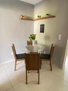 un comedor con mesa y sillas y un gato en un estante en Ap 2 quartos em Ipiabas en Barra do Piraí